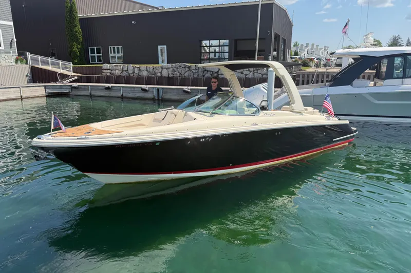 Slide: The Image of 2023 Chris-Craft Launch 28 GT boat docked in marina, featuring sleek design and American flag. - 26