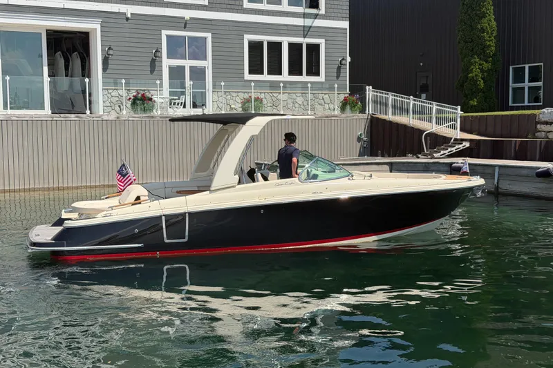 Slide: The Image of 2023 Chris-Craft Launch 28 GT boat docked by a waterfront building. - 27
