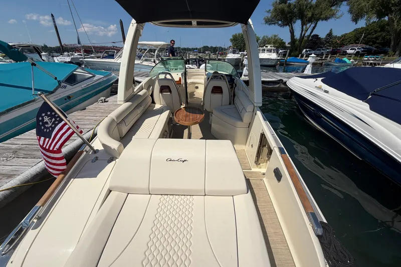 Slide: The Image of 2023 Chris-Craft Launch 28 GT boat docked, featuring elegant seating and American flag. - 3