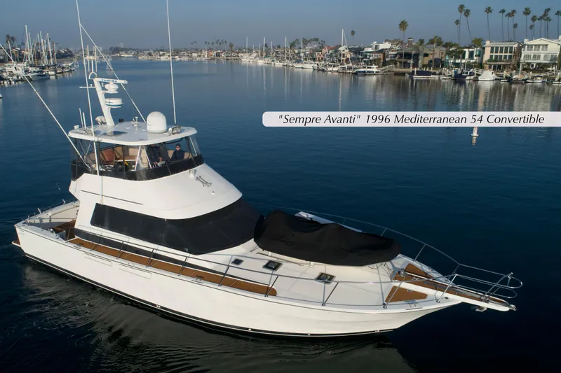 Slide: The Image of 1996 Mediterranean Convertible yacht on calm water, surrounded by marina and coastal homes. - 1