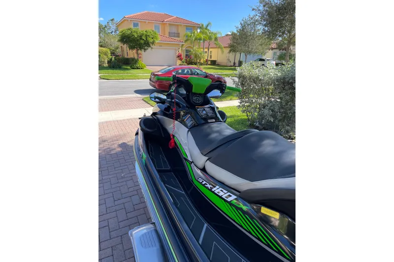 Slide: The Image of 2020 Kawasaki Jetski STX 160LX parked on a residential driveway. - 6