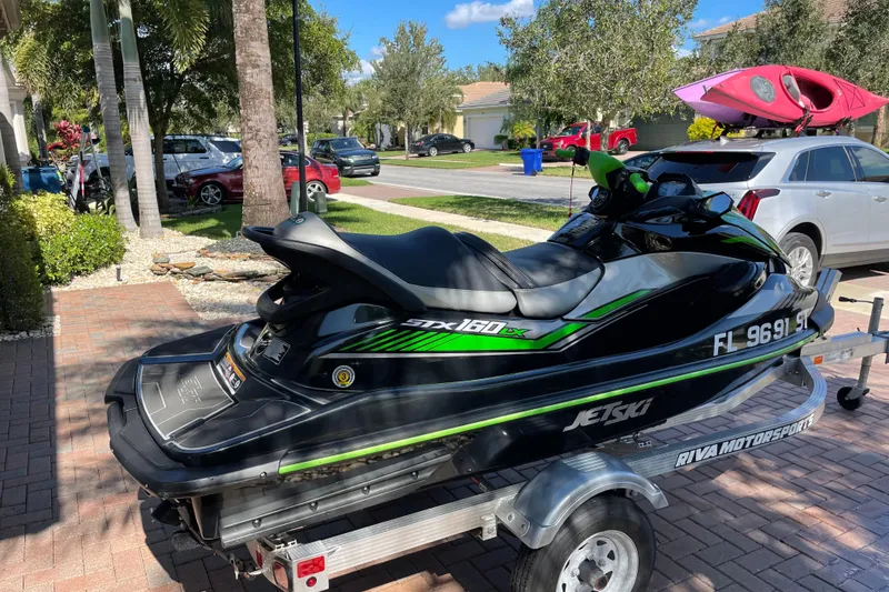 Slide: The Image of 2020 Kawasaki Jetski STX 160LX on trailer in suburban driveway. - 3