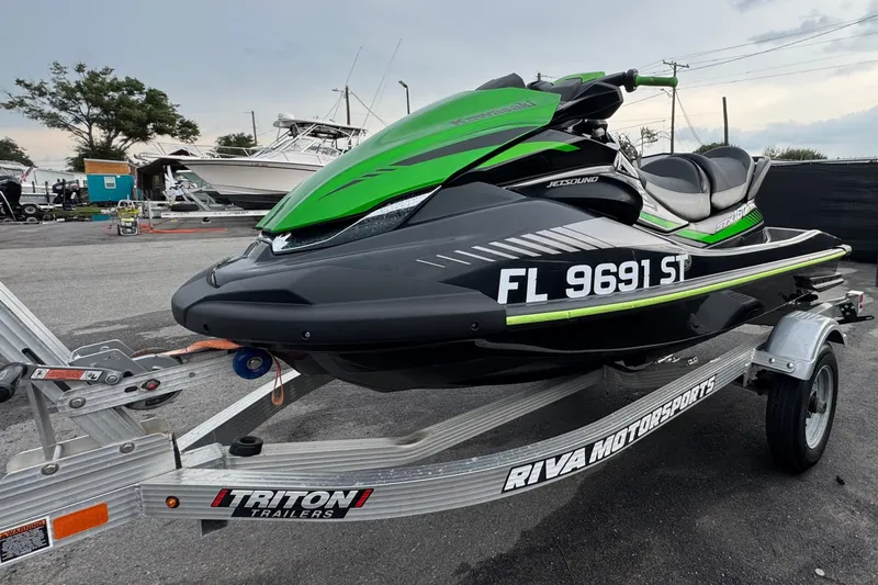 Slide: The Image of A 2020 Kawasaki Jetski STX 160LX on a trailer, parked in an outdoor area. - 6