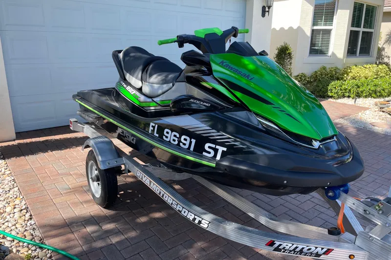 Slide: The Image of 2020 Kawasaki Jetski STX 160LX on trailer, vibrant green and black design. - 2