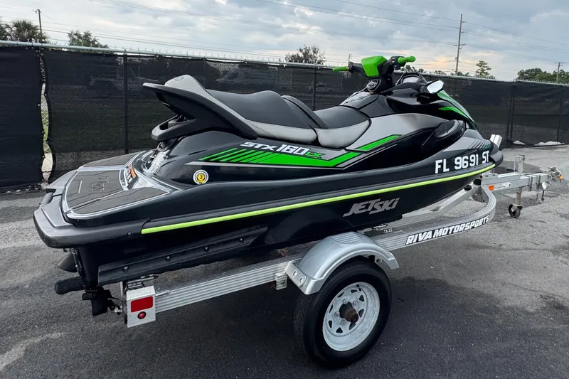 Slide: The Image of A 2020 Kawasaki Jetski STX 160LX is on a trailer in a parking area. - 2