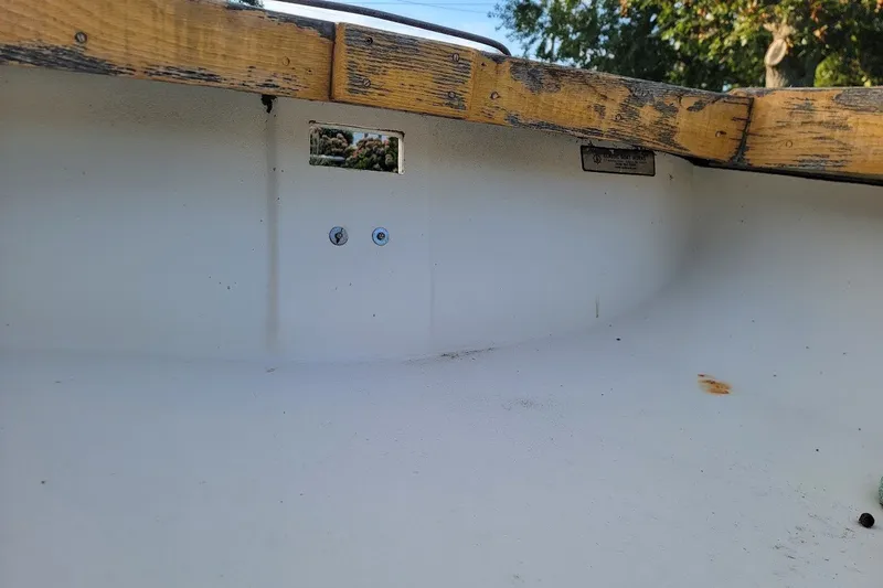 Slide: The Image of Interior of a 1999 Custom Fiberglass Beetle Cat 12 boat with wooden trim. - 24