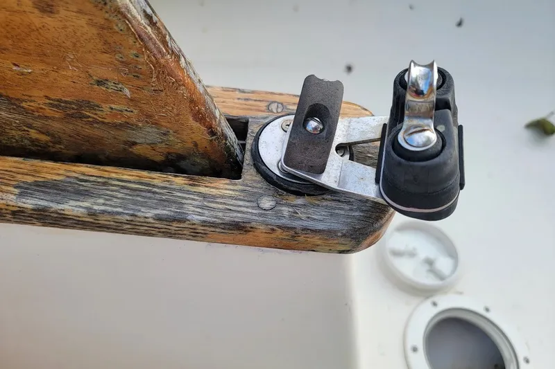 Slide: The Image of Close-up of a 1999 Custom Fiberglass Beetle Cat 12 sailboat's wooden rudder and metal fitting. - 22