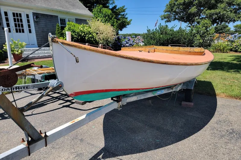Slide: The Image of 1999 Beetle Cat 14 Classic sailboat on trailer, in a garden setting. - 2