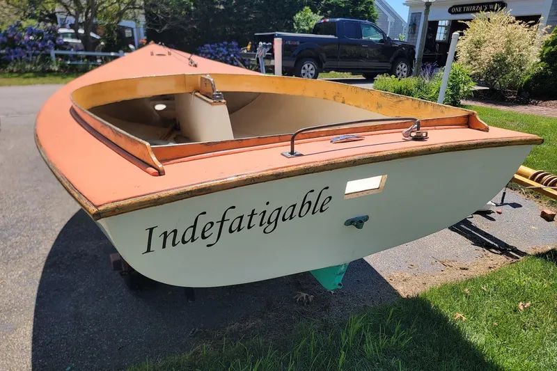Slide: The Image of 1999 Beetle Cat 14 Classic sailboat named "Indefatigable" on a driveway. - 1