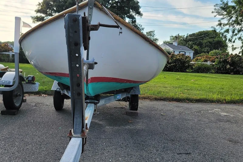 Slide: The Image of A 1999 Custom Fiberglass Beetle Cat 12 sailboat on a trailer, parked on a driveway. - 29