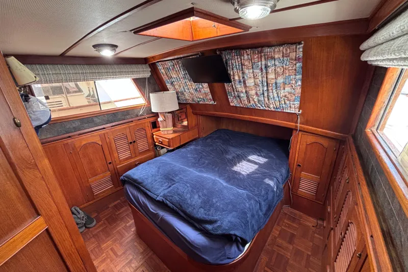 Slide: The Image of Cozy cabin interior of a 1981 Hershine 40 boat with wood paneling and a comfortable bed. - 15