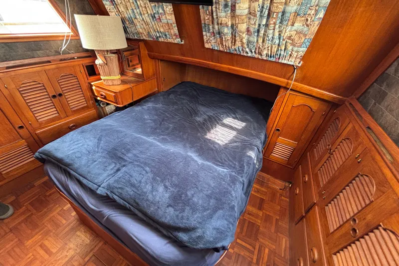 Slide: The Image of Cozy cabin interior of a 1981 Hershine 40 boat with wooden furnishings and a comfortable bed. - 14