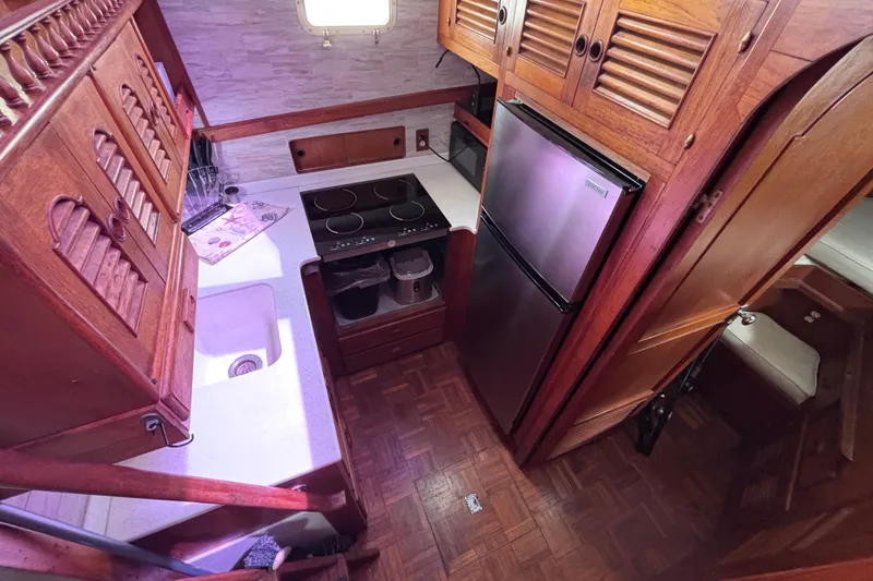 Slide: The Image of 1981 Hershine 40 yacht kitchen with wooden cabinetry, modern appliances, and compact design. - 13