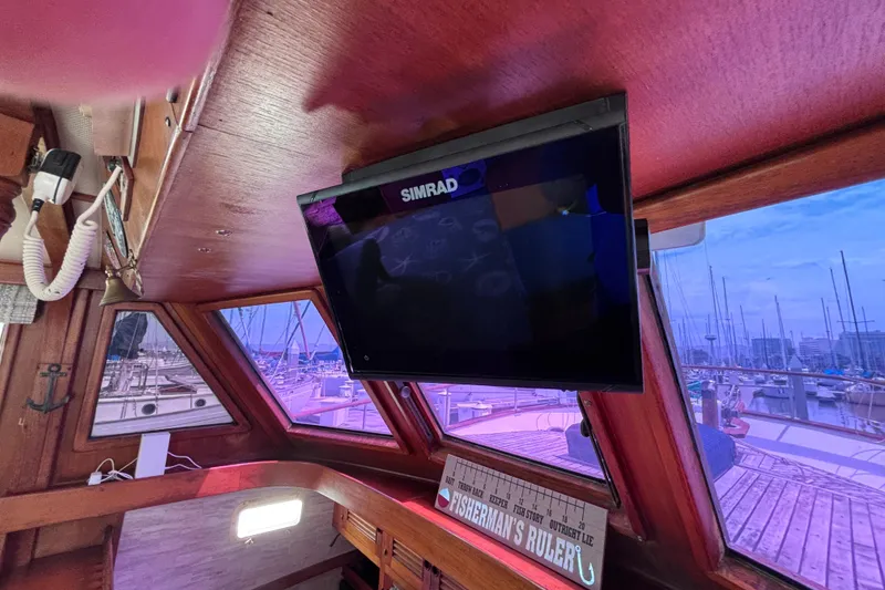Slide: The Image of Interior of 1981 Hershine 40 boat with Simrad display and marina view. - 42