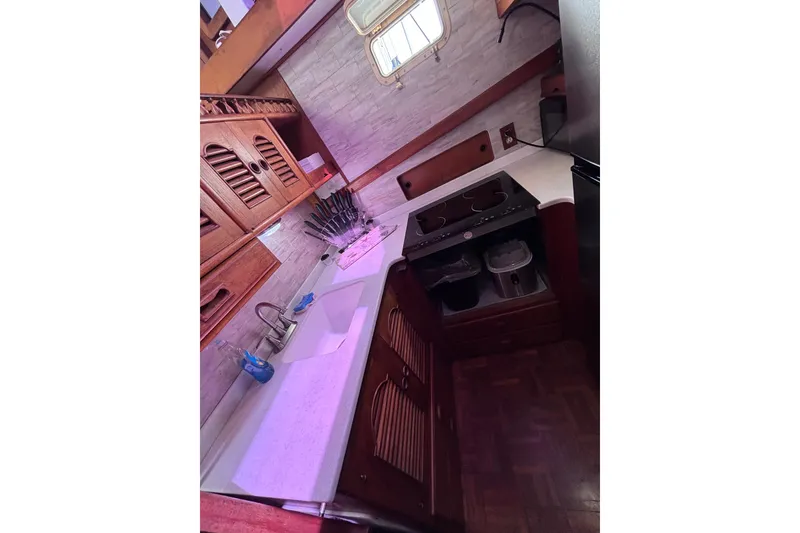 Slide: The Image of 1981 Hershine 40 yacht kitchen with wooden cabinets, stove, and sink. - 35