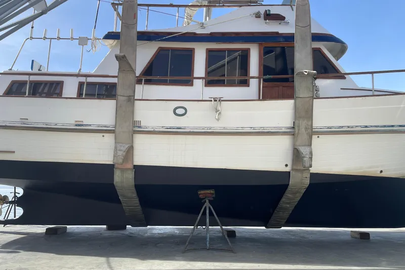 Slide: The Image of 1981 Hershine 40 boat in dry dock, supported by straps and stands. - 28