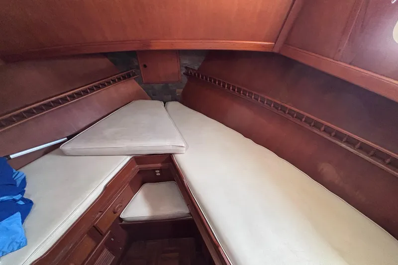 Slide: The Image of Cozy cabin interior of a 1981 Hershine 40 boat with wooden finish and cushioned seating. - 36