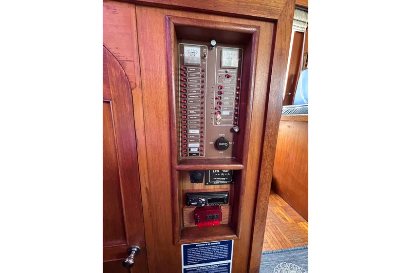 Slide: The Image of Electrical panel on 1981 Hershine 40 boat, featuring switches and controls in wooden cabinet. - 37