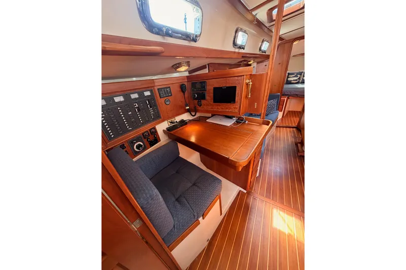 Slide: The Image of Interior of 2002 Tartan 3700 yacht with navigation station and wooden finish. - 60