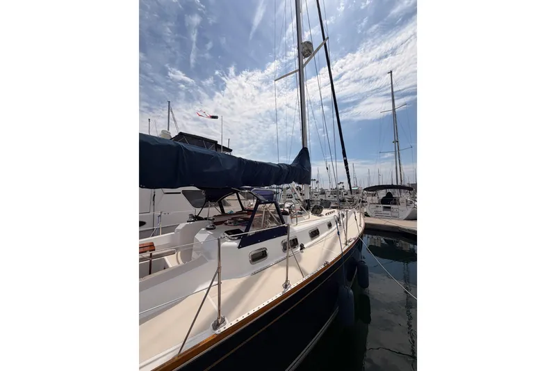 Slide: The Image of 2002 Tartan 3700 sailboat docked at marina under a partly cloudy sky. - 4