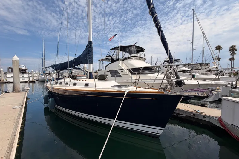 The Image of Sailboat docked at marina, Tartan 3700 model, 2002, under a partly cloudy sky. - 0