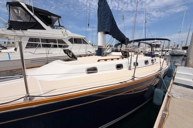 Slide: The Image of 2002 Tartan 3700 sailboat docked at marina under clear sky. - 10