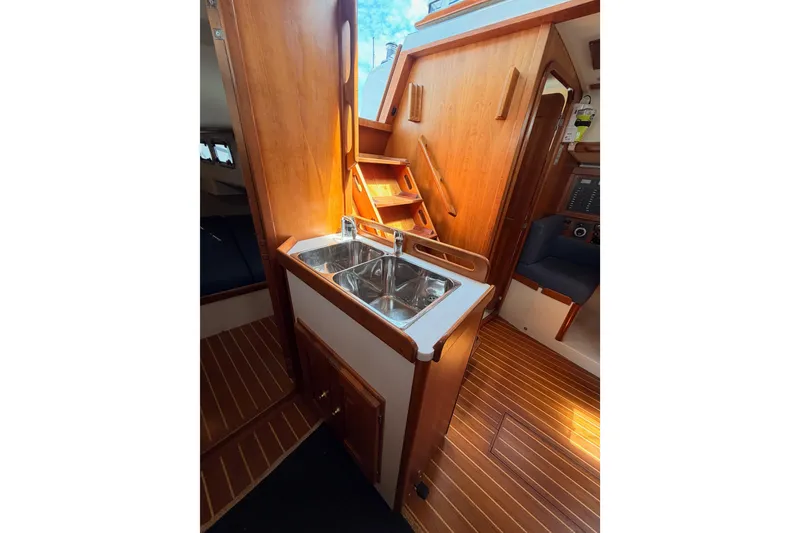 Slide: The Image of Interior of 2002 Tartan 3700 sailboat featuring wooden cabinetry and a stainless steel sink. - 70