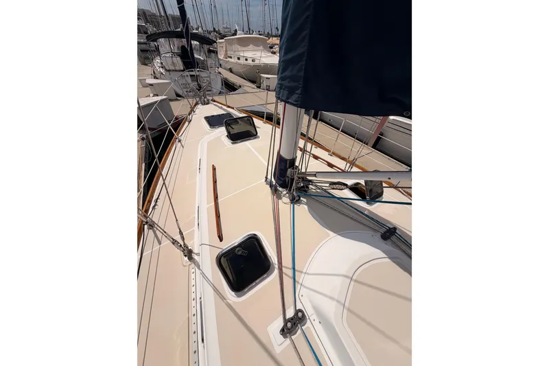 Slide: The Image of 2002 Tartan 3700 sailboat deck view in marina, showcasing rigging and hatches. - 19