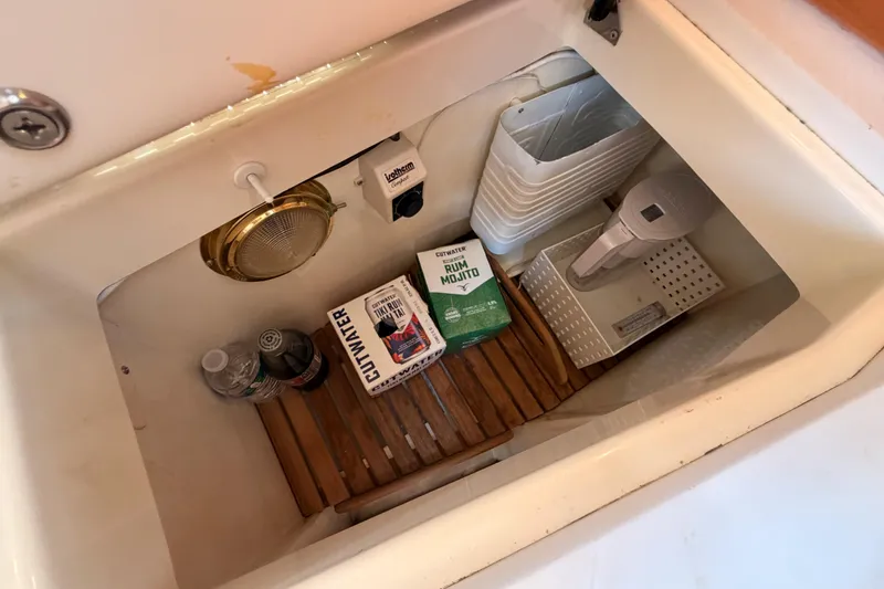 Slide: The Image of Storage compartment in a 2002 Tartan 3700 yacht with beverages and equipment. - 64