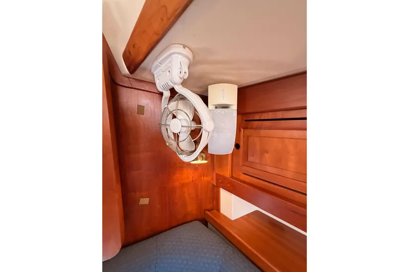 Slide: The Image of Interior of a 2002 Tartan 3700 yacht featuring a mounted fan and wooden cabinetry. - 85