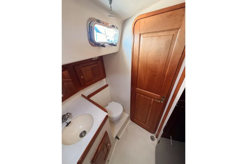 Slide: The Image of Bathroom interior of 2002 Tartan 3700 yacht with wooden cabinetry and porthole window. - 57