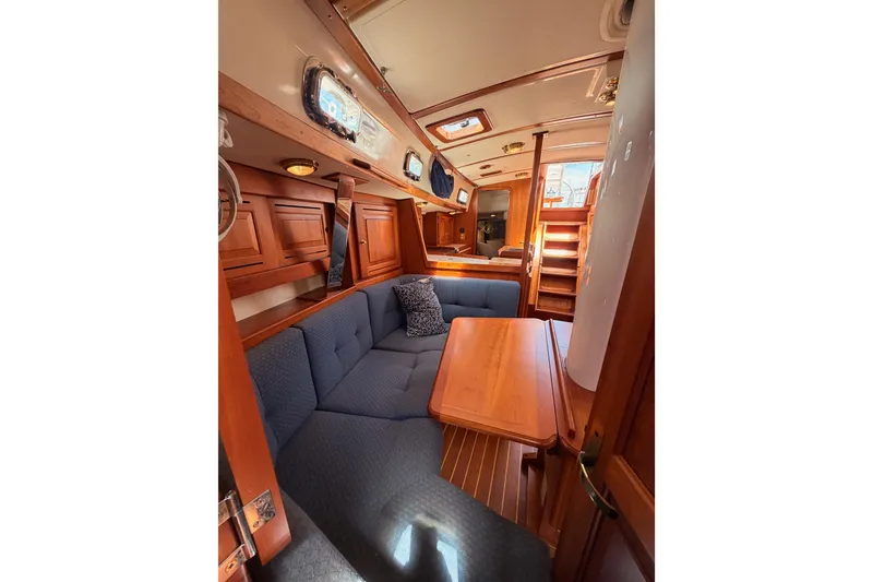 Slide: The Image of Interior of 2002 Tartan 3700 sailboat with wooden furnishings and blue seating. - 96