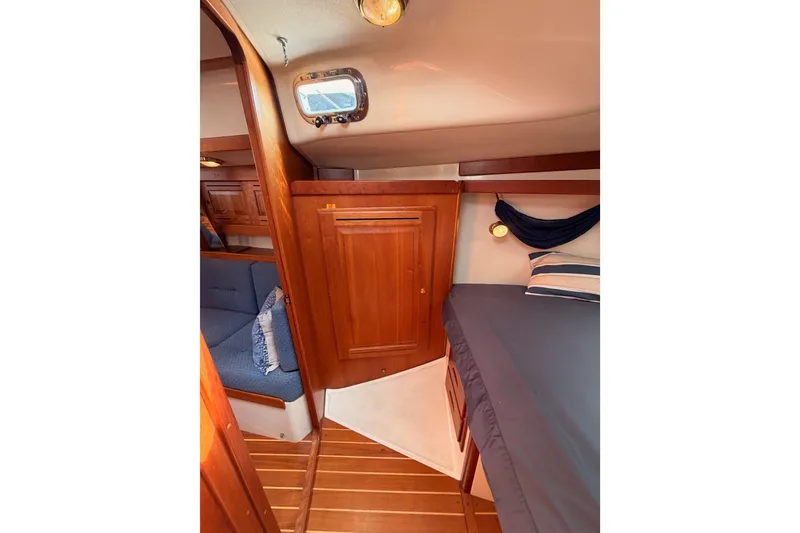 Slide: The Image of Interior of 2002 Tartan 3700 sailboat with wooden cabinetry and cozy sleeping area. - 92