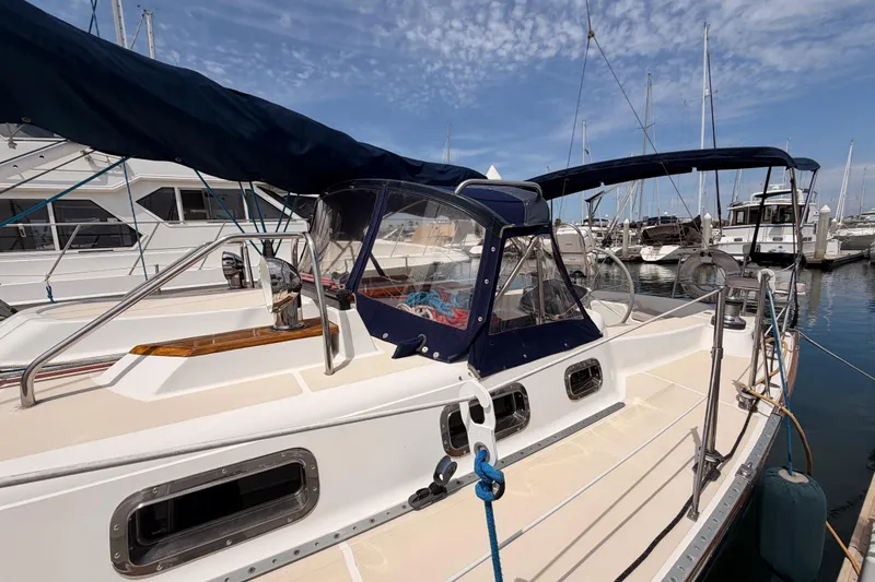 Slide: The Image of Sailboat docked at marina, Tartan 3700 model, 2002, with blue canopy and clear windows. - 12