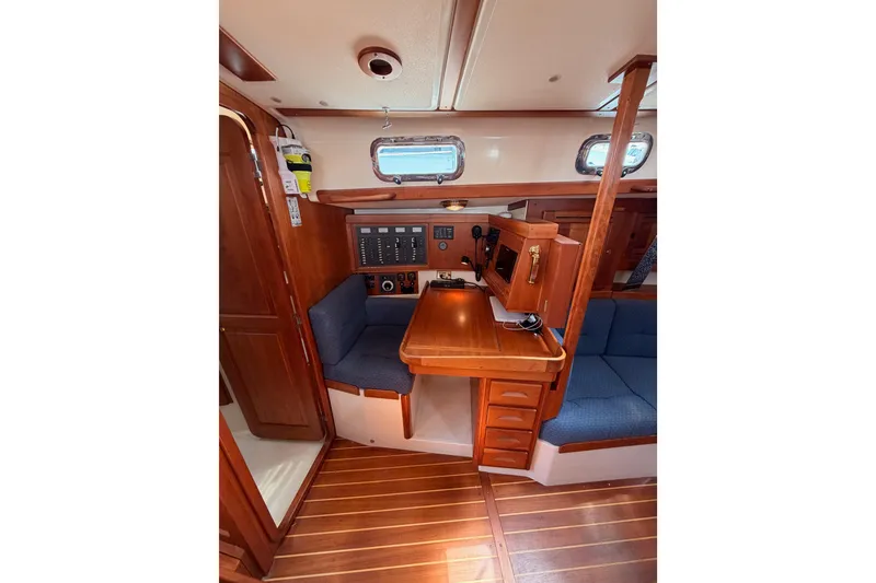 Slide: The Image of Interior of 2002 Tartan 3700 sailboat with wooden cabinetry and blue seating. - 49
