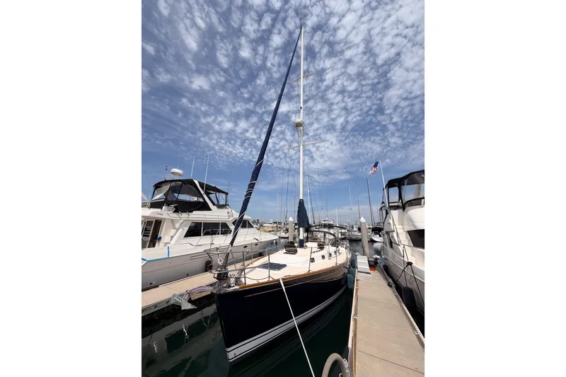 Slide: The Image of Sailboat Tartan 3700 (2002) docked at marina under a partly cloudy sky. - 9