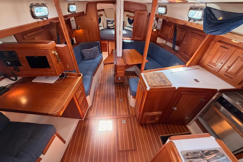 Slide: The Image of Interior of 2002 Tartan 3700 sailboat with wooden cabinetry and blue seating. - 47