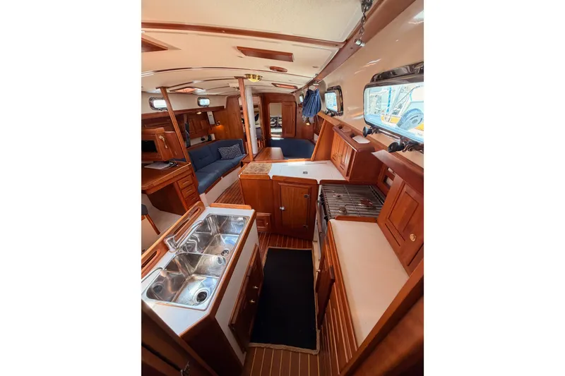 Slide: The Image of Interior of 2002 Tartan 3700 sailboat featuring a well-equipped galley and cozy seating area. - 80