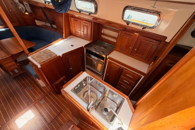 Slide: The Image of Luxurious 2002 Tartan 3700 yacht interior with wooden cabinetry and modern kitchen amenities. - 48
