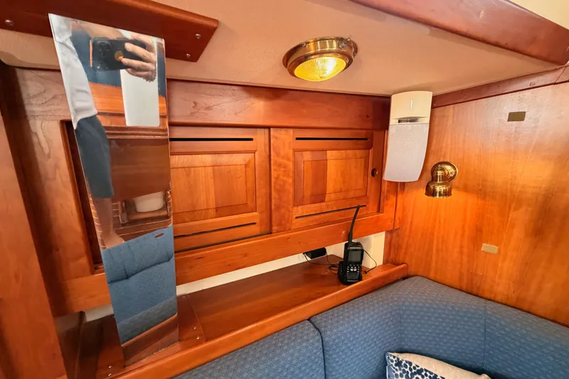 Slide: The Image of Interior of a 2002 Tartan 3700 sailboat with wooden cabinetry and cozy seating area. - 87