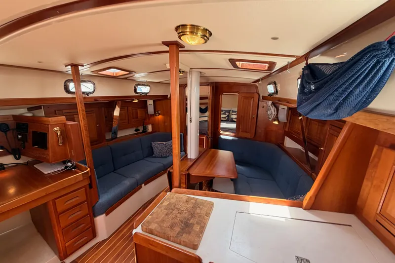Slide: The Image of Interior of 2002 Tartan 3700 sailboat with wooden furnishings and blue seating. - 81