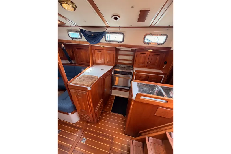 Slide: The Image of Interior of 2002 Tartan 3700 sailboat with wooden cabinetry and compact kitchen area. - 61