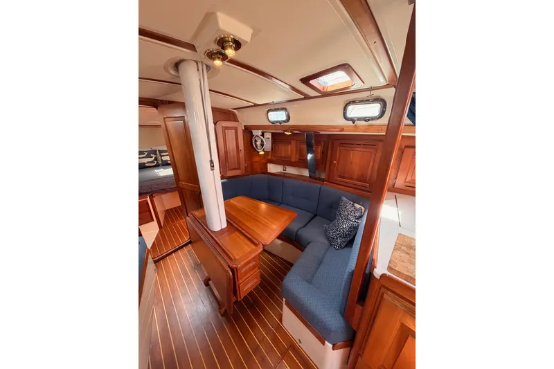 Slide: The Image of Cozy interior of 2002 Tartan 3700 sailboat with wooden finishes and blue seating. - 83