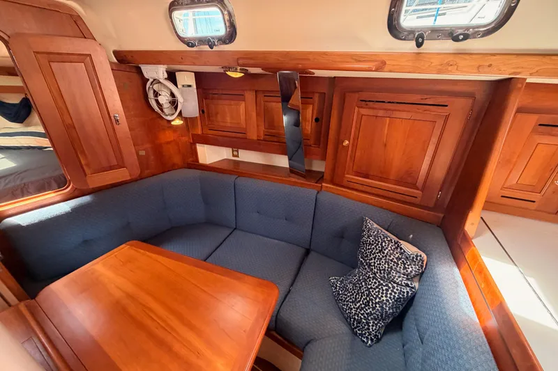 Slide: The Image of Cozy interior of 2002 Tartan 3700 sailboat with wooden cabinetry and blue cushioned seating. - 84