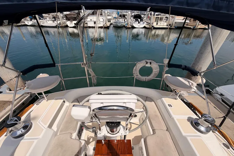 Slide: The Image of Cockpit view of 2002 Tartan 3700 sailboat docked at marina, showcasing helm and seating. - 27