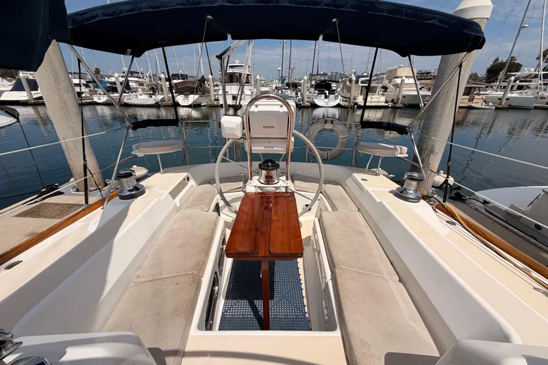 Slide: The Image of 2002 Tartan 3700 sailboat cockpit with wooden table, docked in marina. - 26