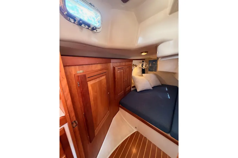 Slide: The Image of Cozy cabin interior of 2002 Tartan 3700 sailboat with wooden cabinetry and blue bedding. - 72