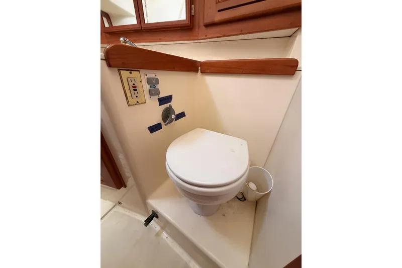 Slide: The Image of Toilet area in 2002 Tartan 3700 yacht with control panel and wooden accents. - 58
