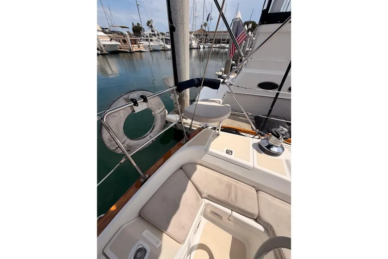 Slide: The Image of 2002 Tartan 3700 sailboat cockpit with marina view, featuring seating and safety equipment. - 30