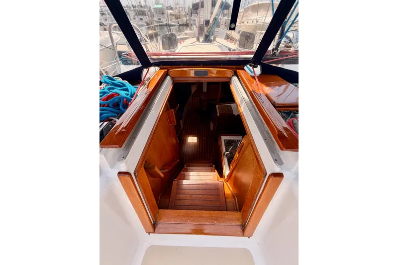 Slide: The Image of Interior view of a 2002 Tartan 3700 sailboat, showcasing wooden stairs and cabin entrance. - 46